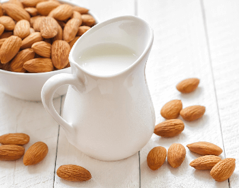 A picture of a glass of almond milk and almonds
